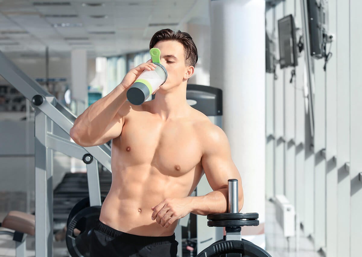 mężczyzna pijący odżywkę białkową